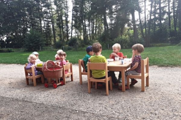 Děti obědvají venku u stolečku